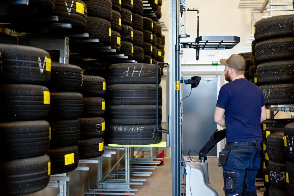 Man använder lyft för ställa in däck i däckhotell