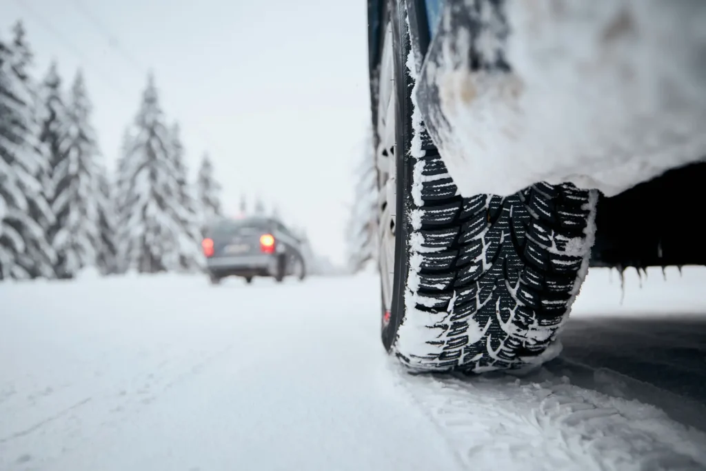 Bildäck på snötäckt vinterväg.