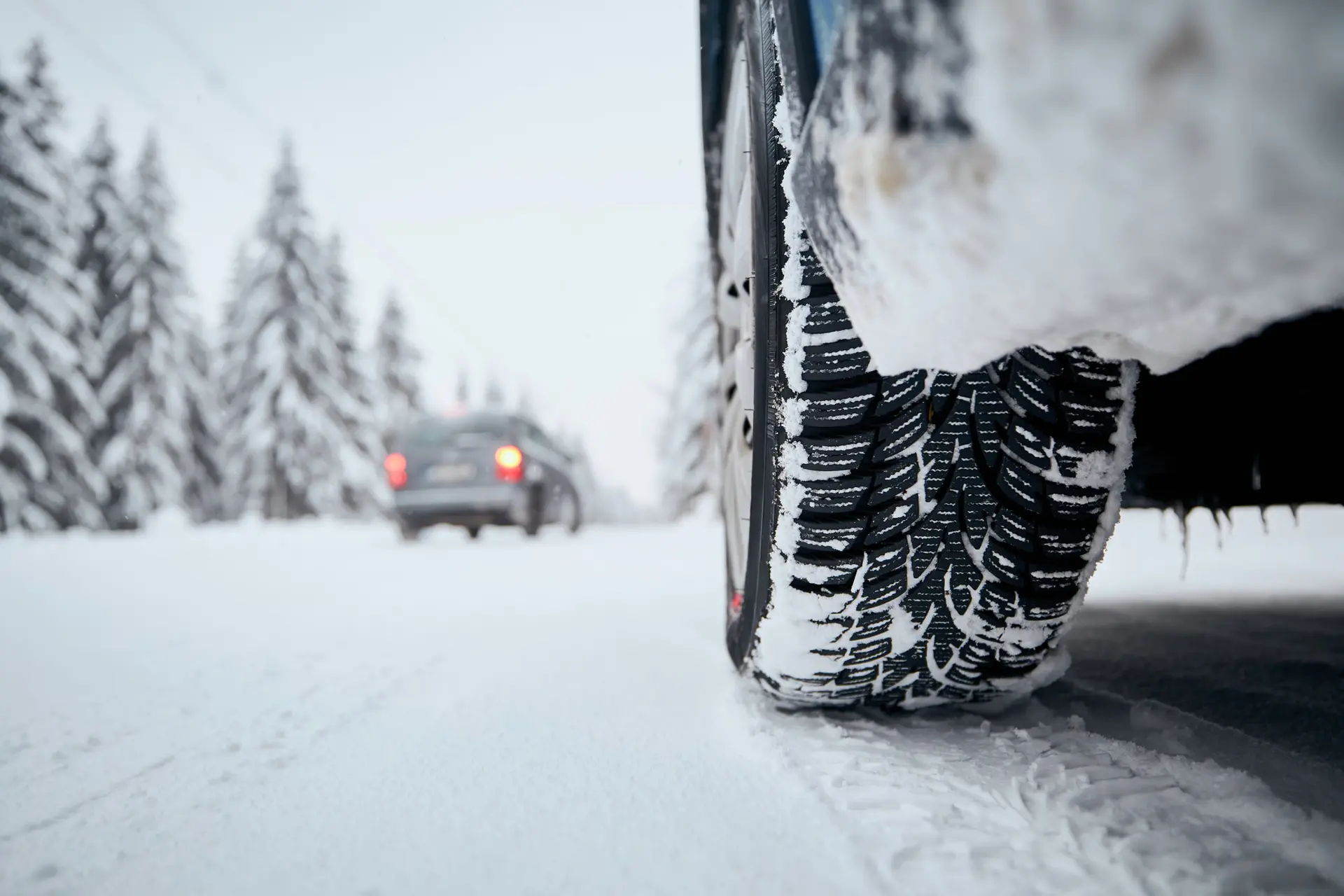 Bildäck på snötäckt vinterväg.