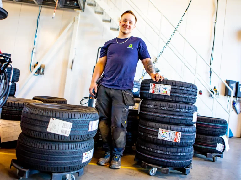 Däcktekniker står vid nya däck.