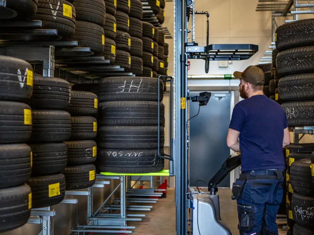 Placerar däck på hylla i däckhotell